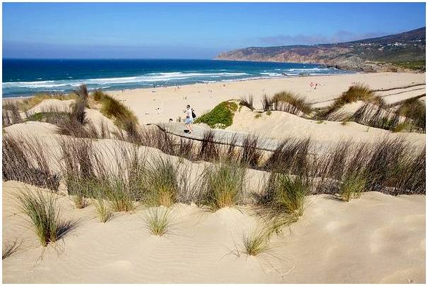Прогулка среди дюн пляжа Гиншу в Португалии.